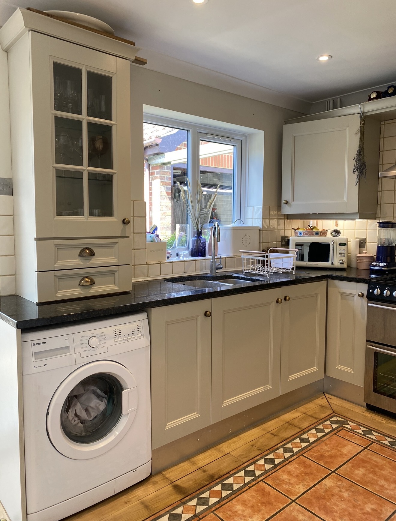 Cream painted kitchen cupboards beside a window and sink