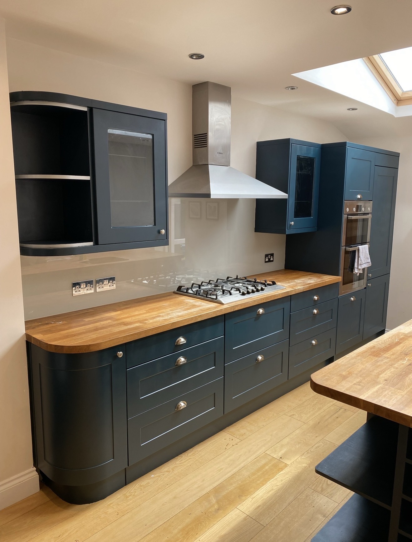Deep blue hand-painted shaker kitchen cabinetry with timber worktops
